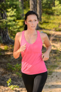 Woman running in the countryside training with headphones