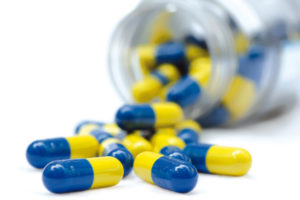 pot of yellow and blue capsule pills
